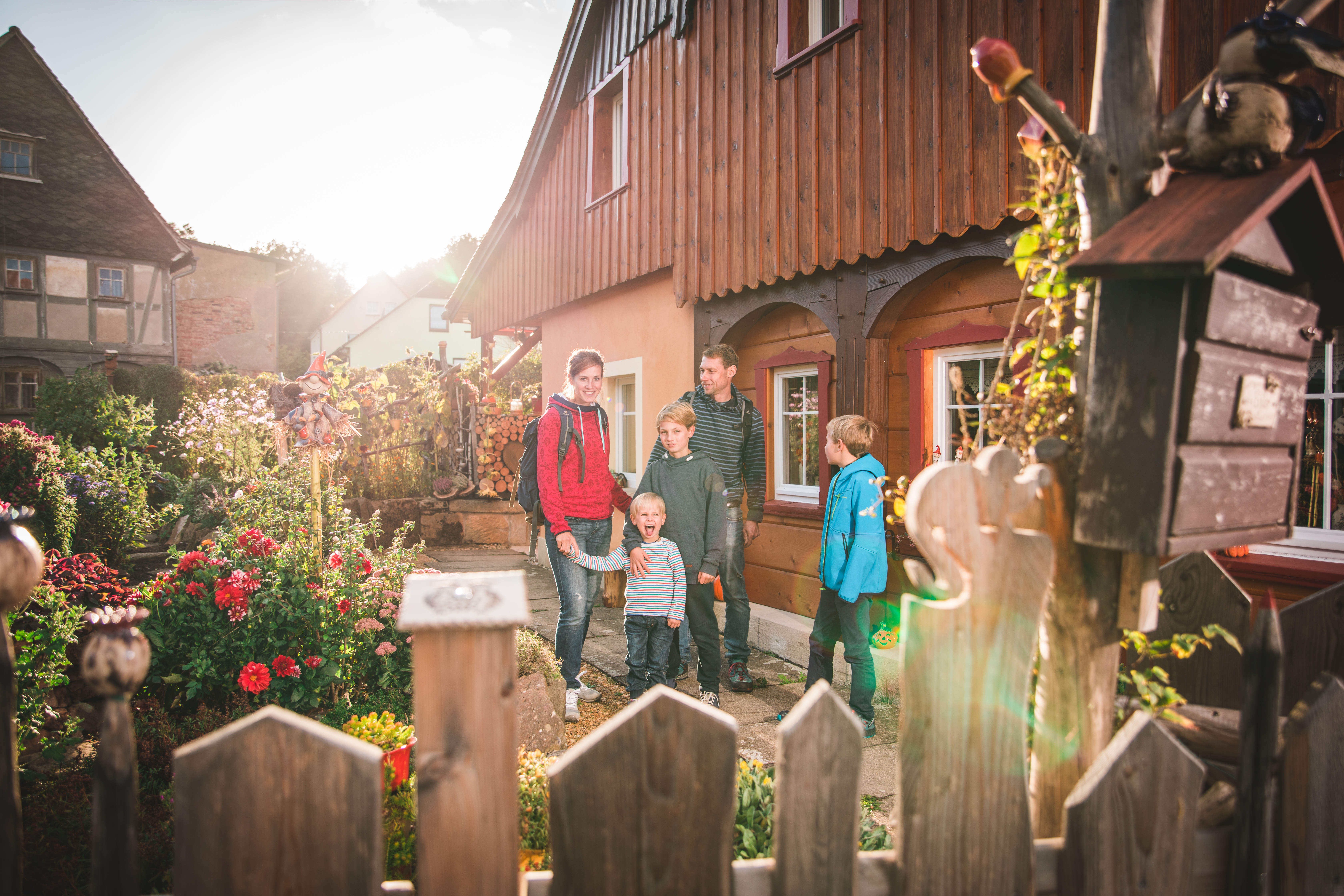 Family in the flower garden in front of a half-timbered house